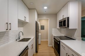 Palo Alto apartment for rent - an empty kitchen with white counters and a sink and a refrigerator