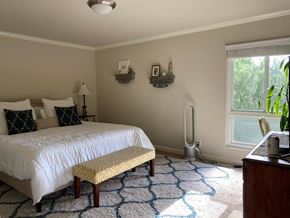 San Mateo apartment for rent - A bedroom with a white bed and a yellow bench.