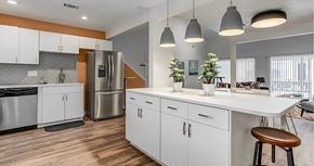 Kansas City apartment for rent - A modern kitchen with white cabinets and a wooden floor.