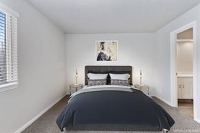 Kansas City apartment for rent - A bedroom with a large bed and a painting on the wall.