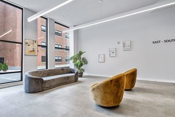Passaic apartment for rent - A modern living room with a large couch and two chairs.