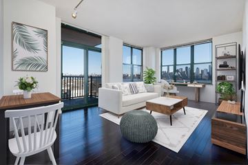 West New York apartment for rent - A modern living room with a white sofa and a wooden coffee table.