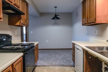 Wayland apartment for rent - A kitchen with a black stove top oven and wooden cabinets.