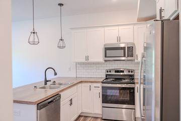 Wyoming apartment for rent - A kitchen with a stainless steel refrigerator and a microwave above the stove.