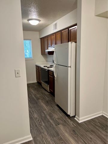 Grand Rapids apartment for rent - A kitchen with a white refrigerator and wooden cabinets.
