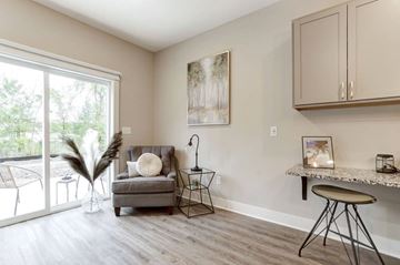 Kentwood apartment for rent - A living room with a grey couch, a small table, and a painting on the wall.