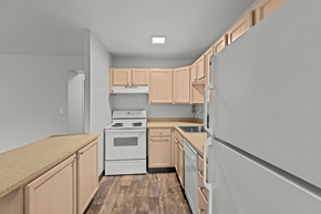 Seattle apartment for rent - A kitchen with wooden cabinets and a white stove top oven