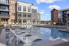 Colorado Springs apartment for rent - A modern pool with a unique design is surrounded by contemporary buildings.