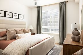 Arvada apartment for rent - a bedroom with a bed and a large window