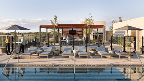 Denver apartment for rent - a pool with lounge chairs and a wooden canopy next to a swimming pool