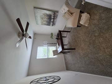 Crescent Springs townhouse for rent - A living room with a fan, a couch, and a painting on the wall.