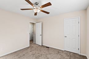 Erlanger triplex for rent - A room with a ceiling fan and carpeted floor.