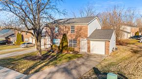 Erlanger triplex for rent - A house with a driveway and a tree in front.