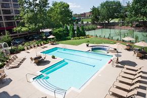 Providence apartment for rent - A large swimming pool surrounded by lounge chairs and trees.