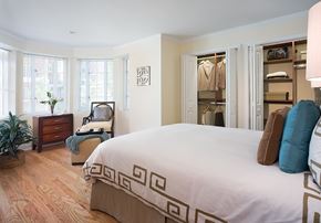 Brookline apartment for rent - A bedroom with a large bed and a chair with a blanket on it.