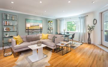 Brookline apartment for rent - A living room with a grey couch, a white coffee table, and a painting on the wall.