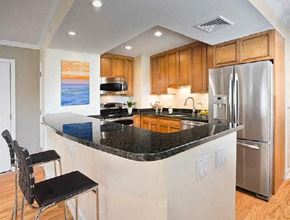 Brookline apartment for rent - A kitchen with a black counter top and stainless steel appliances.