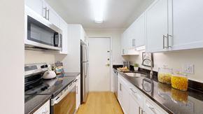 Plainville apartment for rent - A kitchen with white cabinets and black countertops.