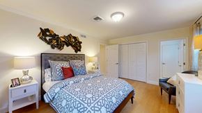 Canton apartment for rent - A bedroom with a large bed and a wooden sculpture on the wall.