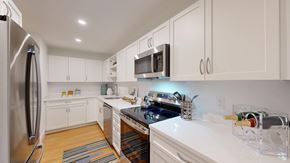 Canton apartment for rent - A kitchen with white cabinets and a stainless steel refrigerator.
