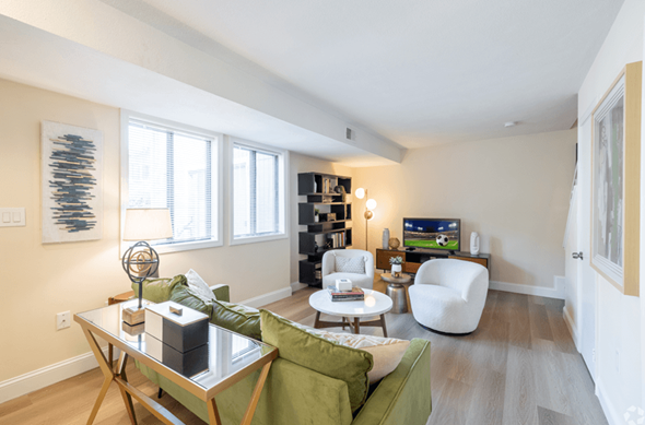 Norwood apartment for rent - A living room with a green couch and a white chair.