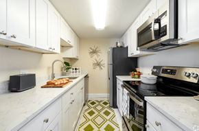 Norwood apartment for rent - A kitchen with white cabinets and a green and white floor.