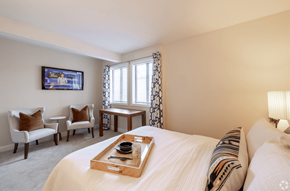 Norwood apartment for rent - A bedroom with a large bed and a flat screen TV mounted on the wall.