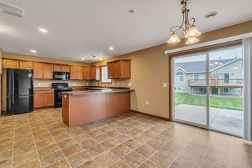 Chippewa Falls apartment for rent - A kitchen with brown cabinets and a black refrigerator.