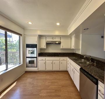 Pasadena apartment for rent - A kitchen with white cabinets and a black countertop.