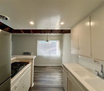 Alhambra apartment for rent - A kitchen with white cabinets and a black stove top.
