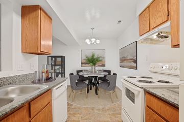 Cottonwood Heights apartment for rent - A kitchen with a table and chairs in the middle.