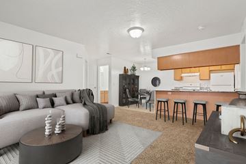 West Jordan apartment for rent - A modern living room with a grey sofa and a wooden coffee table.