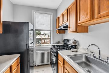 Washington apartment for rent - A kitchen with a black refrigerator and wooden cabinets.