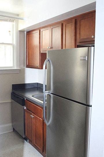Washington apartment for rent - A stainless steel refrigerator with a black handle sits in a kitchen with wooden cabinets.