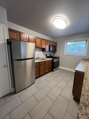 Hyattsville apartment for rent - A kitchen with a refrigerator, microwave, and oven.