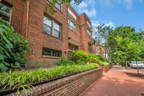 Washington apartment for rent - A red brick building with a green lawn in front.