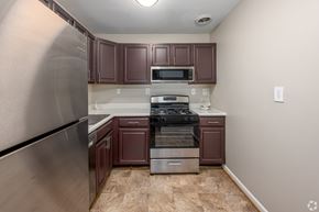 Hyattsville apartment for rent - A kitchen with brown cabinets and a stainless steel refrigerator.