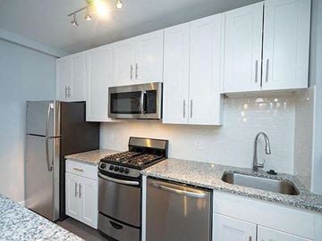 Washington apartment for rent - A kitchen with white cabinets and stainless steel appliances.