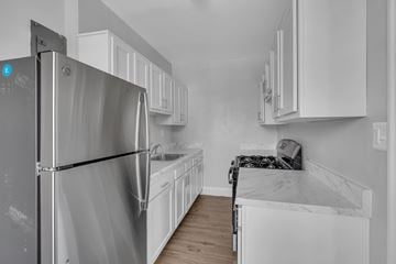 Washington apartment for rent - A kitchen with white cabinets and a stainless steel refrigerator.