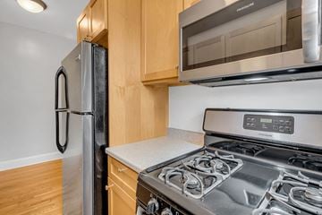 Washington apartment for rent - A modern kitchen with a stainless steel stove and a black refrigerator.