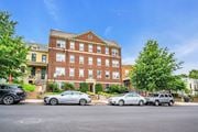 Washington apartment for rent - a large brick building with cars parked in front of it