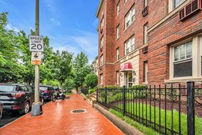 Washington apartment for rent - a sidewalk in front of a brick building with a speed limit sign