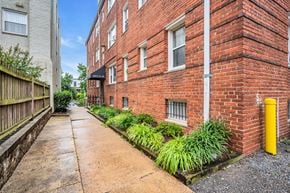 Washington apartment for rent - a brick building with a sidewalk and a yellow pole