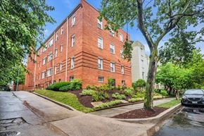 Washington apartment for rent - exterior view of a red brick apartment building on a rainy day