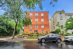 Washington apartment for rent - an apartment building on a rainy street with a car parked in front