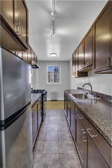 Washington apartment for rent - A kitchen with a stainless steel refrigerator and wooden cabinets.