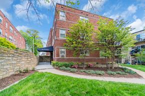 Washington apartment for rent - exterior view of a brick building with green grass and trees