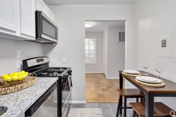 Lanham apartment for rent - A kitchen with a black stove top oven and a black microwave above it.
