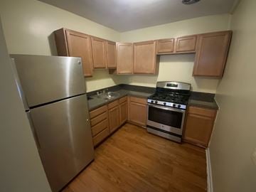 Silver Spring apartment for rent - A kitchen with wooden cabinets and a stainless steel refrigerator.