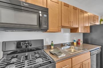 Washington apartment for rent - A modern kitchen with a black stove top oven and a black microwave above it.